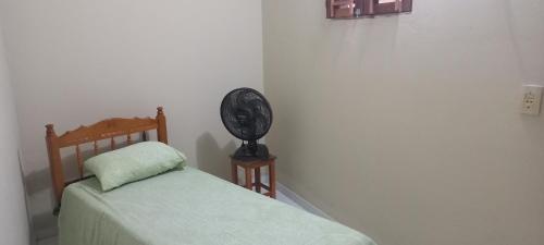 a bedroom with a bed and a clock on a table at Casa de Lagoa Nova in Martins