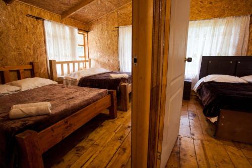 a bedroom with two beds in a room with wooden floors at Hotel Santa M la Cocha in Pasto
