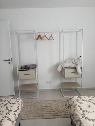 a white bedroom with a teddy bear sitting on a shelf at Domi Apartment in Gerolstein