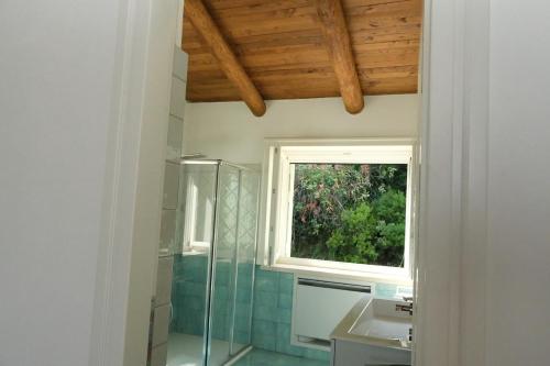 a bathroom with a shower and a sink and a window at The Wonder 400m from the Sea in Scario