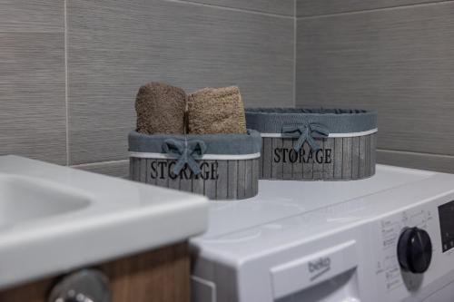 two baskets sitting on top of a washing machine at 20th Floor Amazing View, Spa & Fitness Parking APT in Skopje
