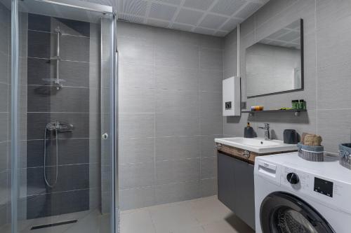 a bathroom with a shower and a washing machine at 20th Floor Amazing View, Spa & Fitness Parking APT in Skopje