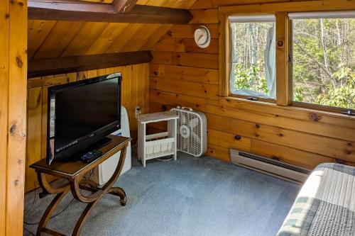 a living room with a flat screen tv in a cabin at Birch Grove Cabin in Fort Edgecomb