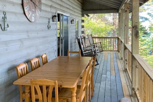 a wooden table on a porch with chairs at Birch Grove Cabin in Fort Edgecomb