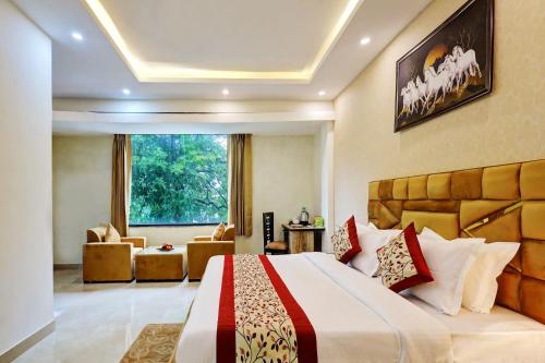 a bedroom with a large bed and a living room at Hotel Golden Era-Near Shopprix Mall in Noida