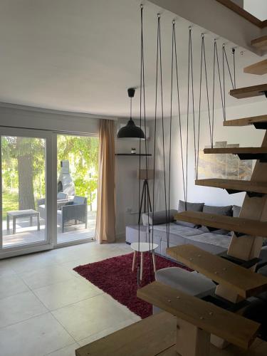 a living room with a staircase and a table at Vikendica Mir Čortanovci in Čortanovci