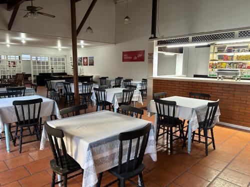 a restaurant with tables and chairs with white table cloth at Hotel Praia Bonita in Capão da Canoa