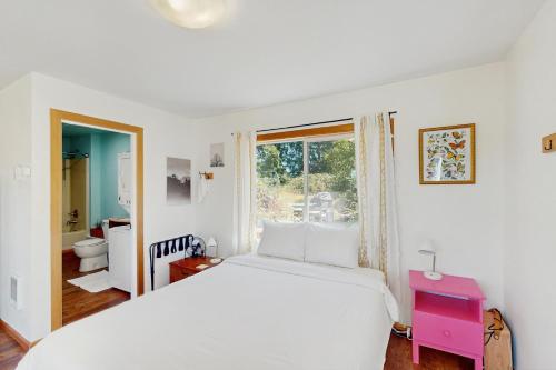 a white bedroom with a large bed and a window at The Friendly Studio in Deerhorn
