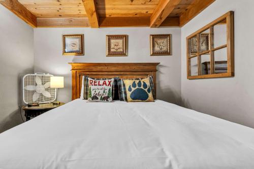 a bedroom with a white bed with a wooden headboard at Peaceful Getaway Pet Friendly with Hot Tub and Grill in Tahoe City