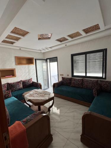 a living room with couches and a table at Résidence oasis beach mansouriah in Mohammedia