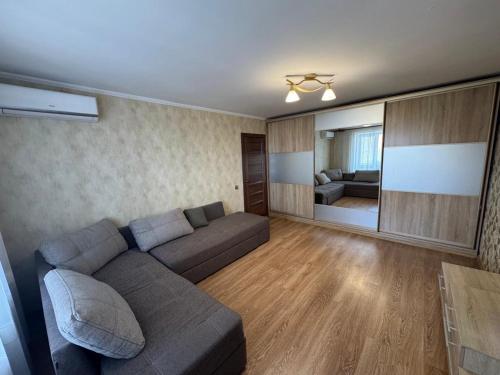 a living room with a couch and a room with a bed at Gerasima Kondratyeva 152 in Sumy