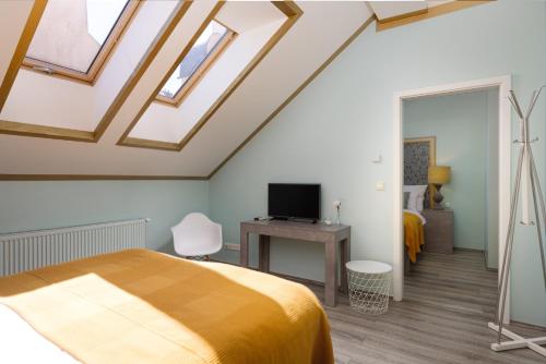 a bedroom with a bed and a desk with a television at Salvatore Prague Rooms in Prague
