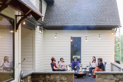 a group of women sitting on the patio of a house at The Indigo House, an adults only, modern bed and breakfast for outdoorsy humans and kind dogs in Afton
