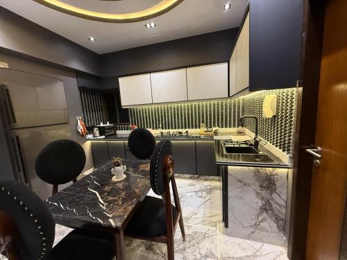 a kitchen with a table and chairs and a counter at 2 bedrooms with attached baths in Karachi