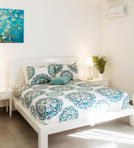 a white bed with a blue and white comforter at SOL CARIBE VILLAGE - STUDIOS DELUXE - playa LOS CORALES in Punta Cana