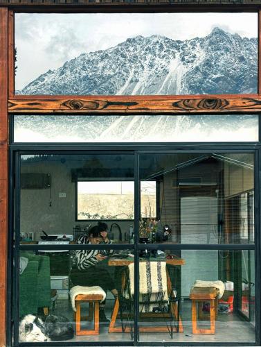 a woman sitting at a table with a mountain in the background at Rest in the mountains in El Bolsón
