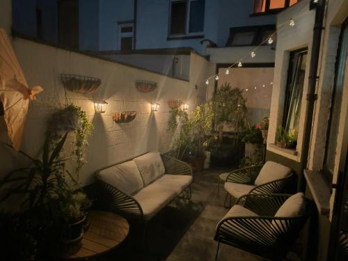 a patio with couches and plants and lights at 2Bangkok residence in Ghent