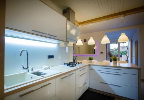 a large white kitchen with a sink and a tub at Apartments Spomenka in Mundanije