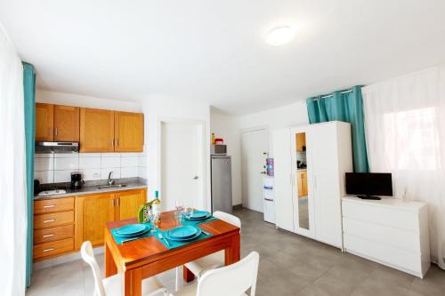a kitchen with a wooden table and a dining room at SOL CARIBE VILLAGE - STUDIOS DELUXE - playa LOS CORALES in Punta Cana