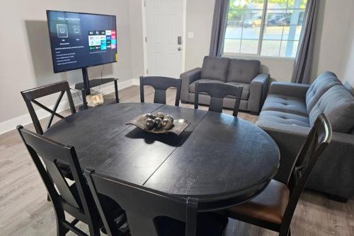 a living room with a table and a tv at Charming 4br Bundle Near Downtown & Airport in Austin