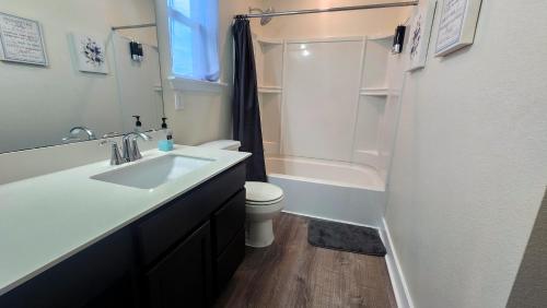 a bathroom with a sink and a toilet and a shower at Luxury Home Near Mckinney Falls & Airport in Austin