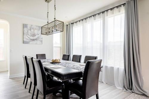 a dining room with a black table and black chairs at Luxury Home Near Mckinney Falls & Airport in Austin
