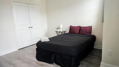 a bedroom with a large black bed with purple pillows at Luxury Home Near Mckinney Falls & Airport in Austin