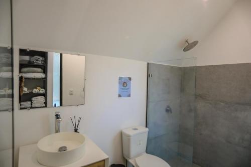 a bathroom with a toilet and a sink and a shower at D'Village 8 - 1 bdr loft in Mal País in Mal País