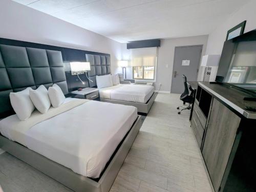 a hotel room with a large bed and a desk at SOHO Suites Atlantic City Beach Block in Atlantic City
