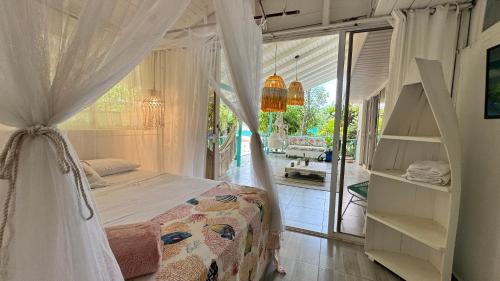 a bedroom with a canopy bed and a balcony at Siloe Cove Hospedaje Campestre in San Andrés