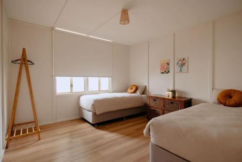 a bedroom with two beds and a tripod in it at Casa Agonis in Geographe