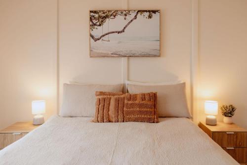 a bedroom with a white bed with two lamps at Casa Agonis in Geographe