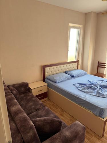 a bedroom with a bed and a chair in it at Studio holidays in Shëngjin