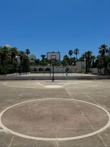 an empty basketball court with a basketball hoop at Appartement pied sur mer in Fnidek