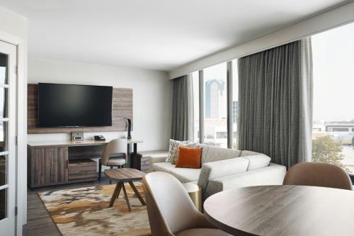 a living room with a couch and a tv at Chicago Marriott Oak Brook in Oak Brook