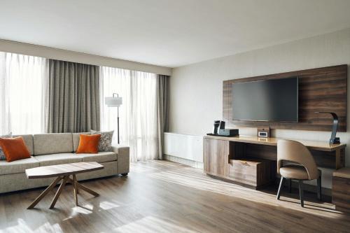 a living room with a couch and a tv at Chicago Marriott Oak Brook in Oak Brook