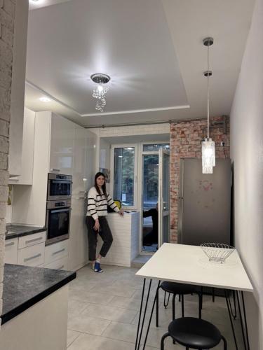 a woman standing at a counter in a kitchen at Апартаменти новобудова Львів in Lviv