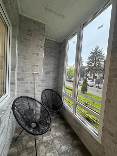 two chairs sitting in front of a window at Апартаменти новобудова Львів in Lviv