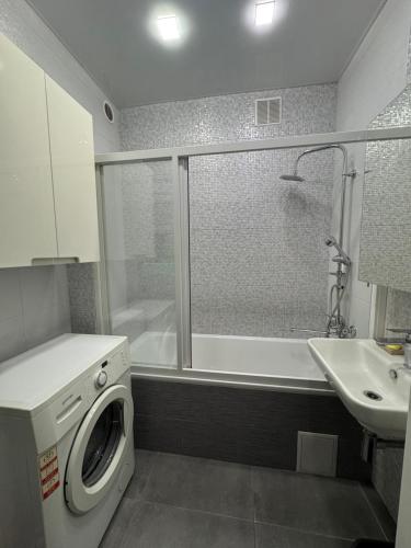 a bathroom with a washing machine and a sink at Апартаменти новобудова Львів in Lviv