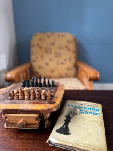 a chess board on a table next to a book at The Rose & Pearl Retreat in Ballintober