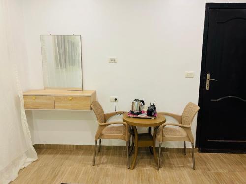 a table and two chairs and a table and a mirror at Farida Pyramids ŌTEL in Cairo
