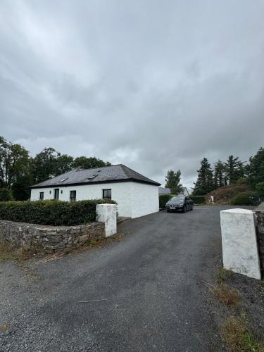 a car parked in front of a white building at The Rose & Pearl Retreat in Ballintober