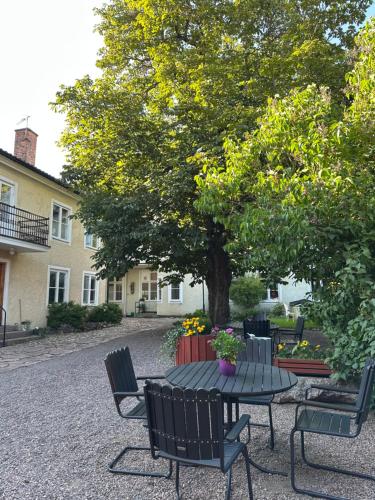 une table de pique-nique et des chaises sous un arbre dans l'établissement Stora Torget B&B, à Eksjö