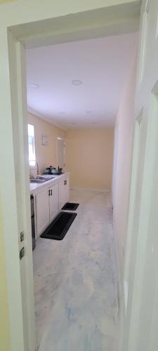 an empty room with a kitchen and a hallway at Oceanview Suites in Saint Georgeʼs