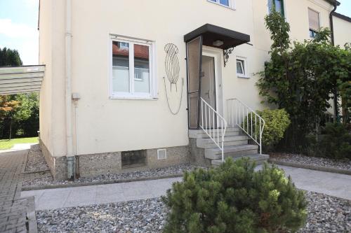 a white house with a white door and stairs at Ferienglück Rosenheim in Rosenheim