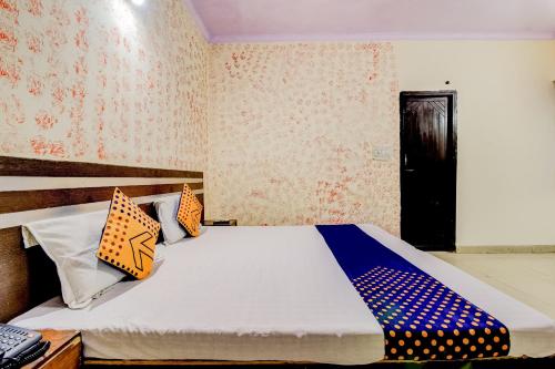 a bedroom with a bed with blue and orange pillows at Spot On Swagat Palace in New Delhi