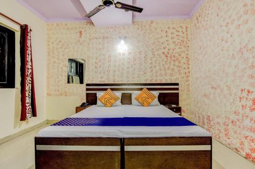 a bedroom with a bed in a room with wallpaper at Spot On Swagat Palace in New Delhi