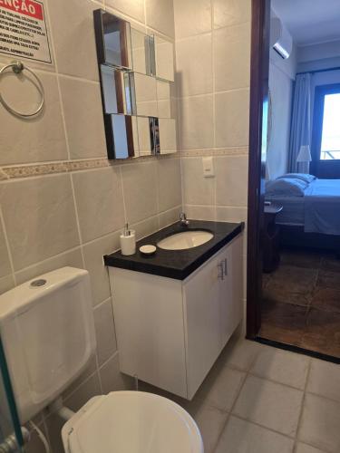 a bathroom with a toilet and a sink at Cumbuco Penthouse - Som do Mar - Pé Na Areia - Ocean View - Ar Condicionado, perto do centro, 2 dormitórios, piscina, cozinha in Cumbuco