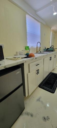 a kitchen with white cabinets and a sink and a window at Oceanview Suites in Saint Georgeʼs