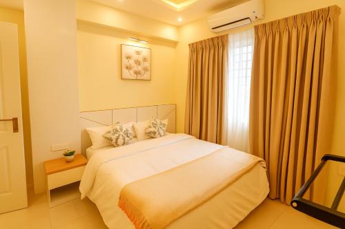 a bedroom with a white bed and a window at Brand New 3BR Condo 5 Min Walk to T Nagar Shopping in Chennai